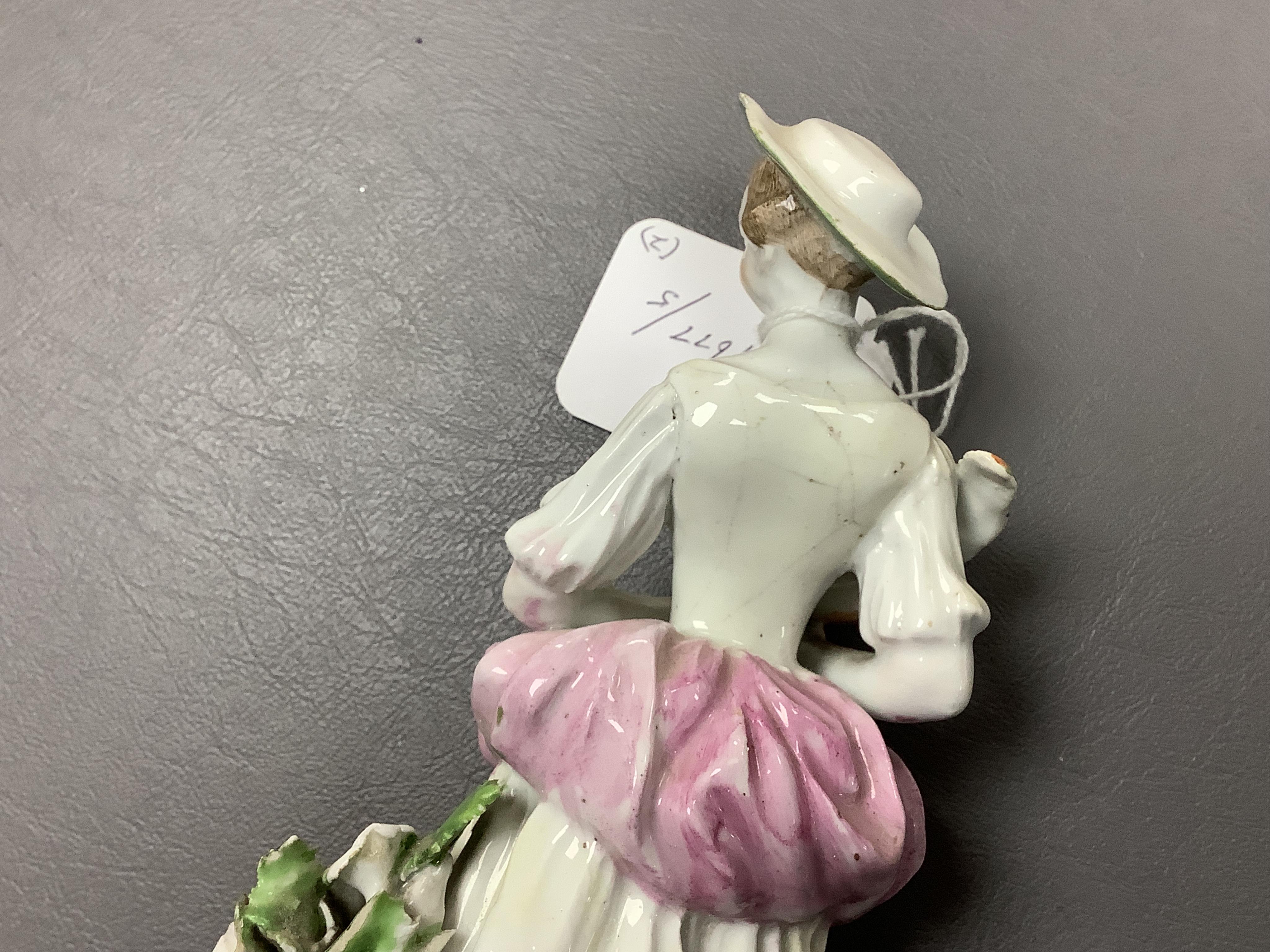A Derby porcelain figure of a lady holding a bird, c.1760-65 and a Derby porcelain figure of a gentleman fruit seller, largest 24cm high (2)